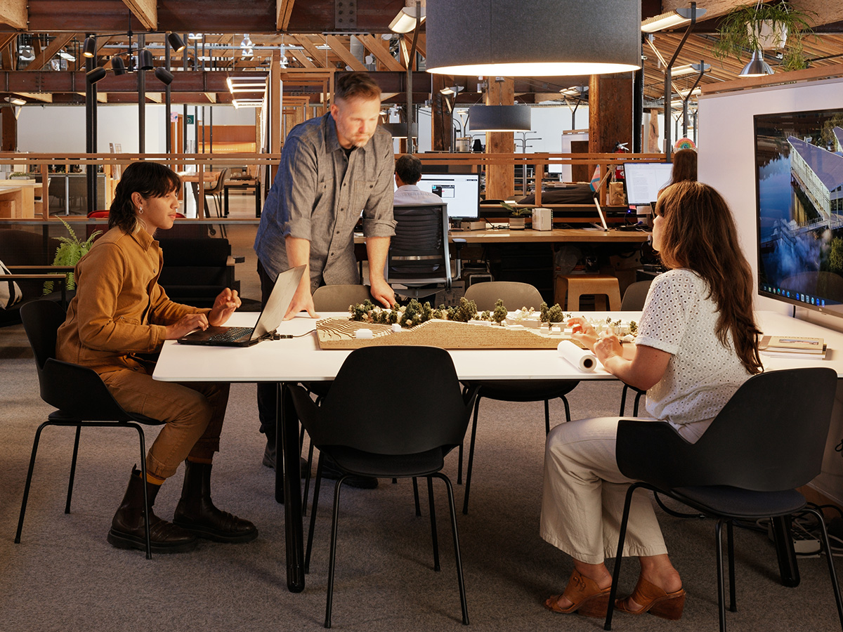 Three people collaborate around a table